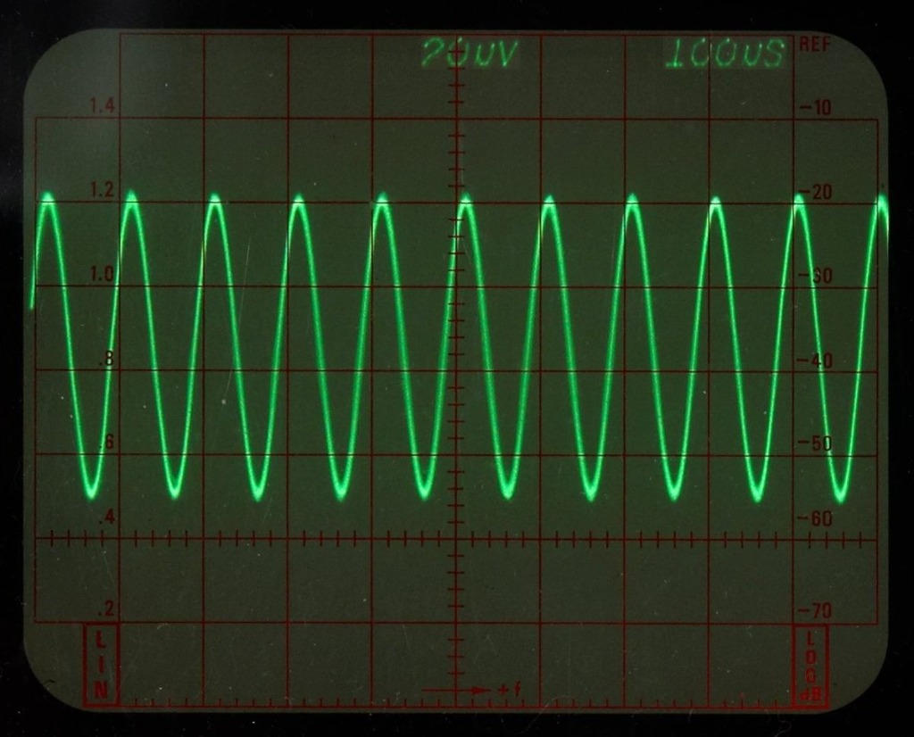 Oscilloscope displaying sine wave signal during electrical testing