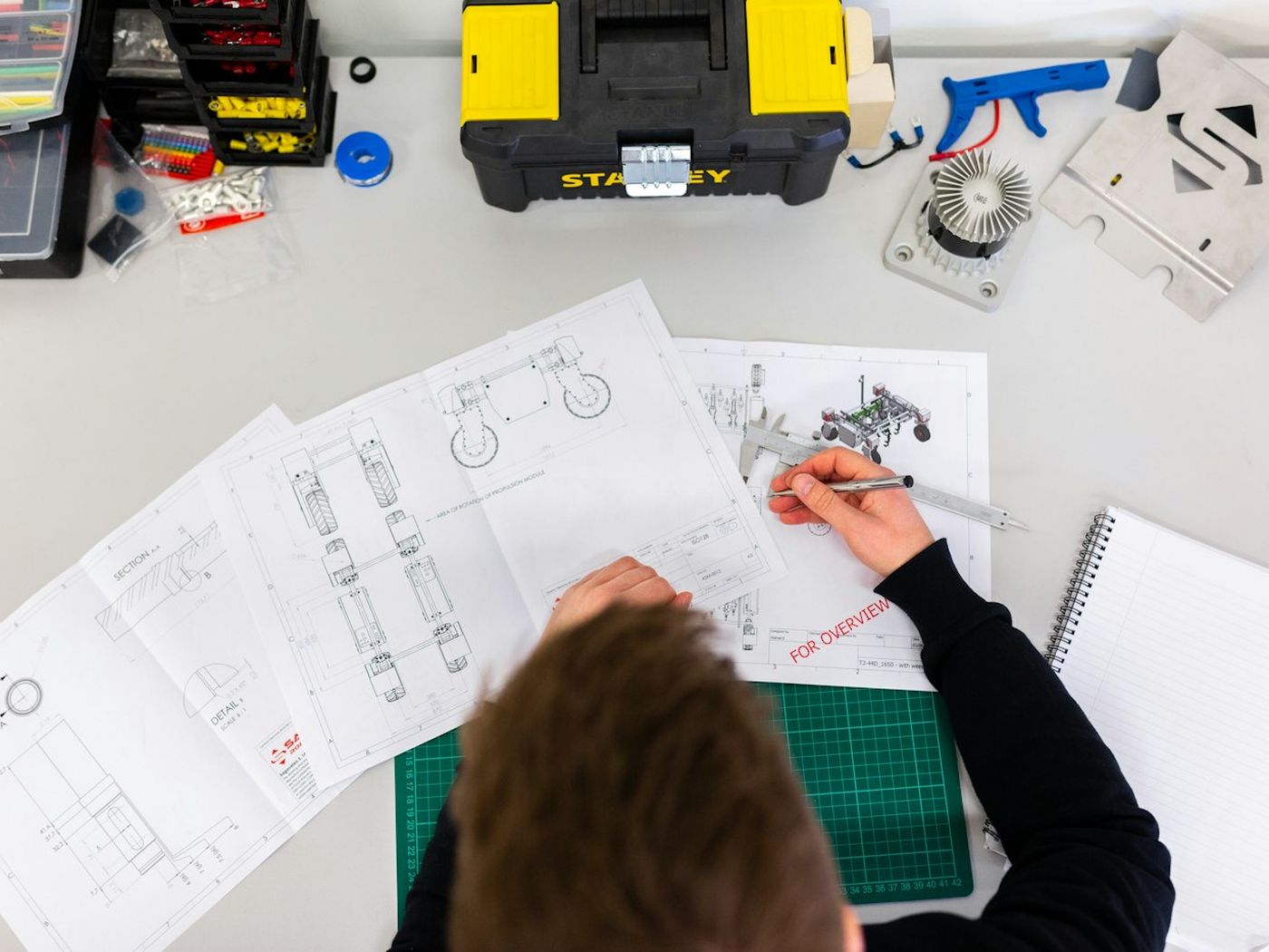 Technical drawings and measurement tools laid out on a workbench